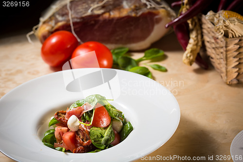 Image of Salad with strawberry, prosciutto, herbs, cottage cheese and blackberry balsamic vinegar.