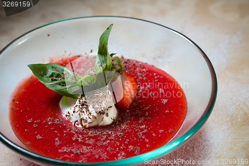 Image of strawberry soup with ice cream and mint on a plate decoratedfresh strawberries