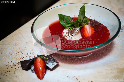 Image of strawberry soup with ice cream and mint on a plate decoratedfresh strawberries