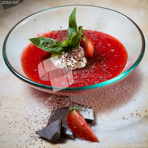 Image of strawberry soup with ice cream and mint on a plate decoratedfresh strawberries