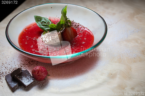 Image of strawberry soup with ice cream and mint on a plate decoratedfresh strawberries