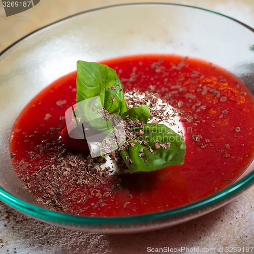Image of strawberry soup with ice cream and mint on a plate decoratedfresh strawberries