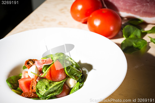 Image of Salad with strawberry, prosciutto, herbs, cottage cheese and blackberry balsamic vinegar.