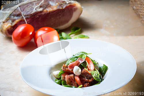 Image of Salad with strawberry, prosciutto, herbs, cottage cheese and blackberry balsamic vinegar.