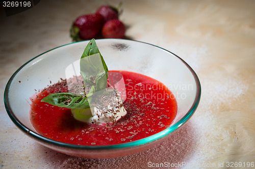 Image of strawberry soup with ice cream and mint on a plate decoratedfresh strawberries