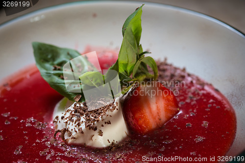 Image of strawberry soup with ice cream and mint on a plate decoratedfresh strawberries