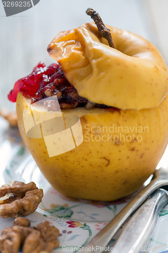 Image of Baked apple with nuts and berries.