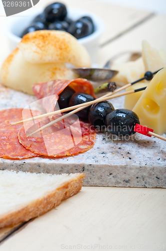 Image of mix cold cut on a stone with fresh pears