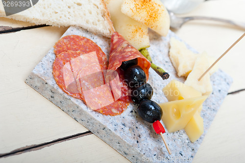 Image of mix cold cut on a stone with fresh pears