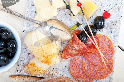 Image of mix cold cut on a stone with fresh pears