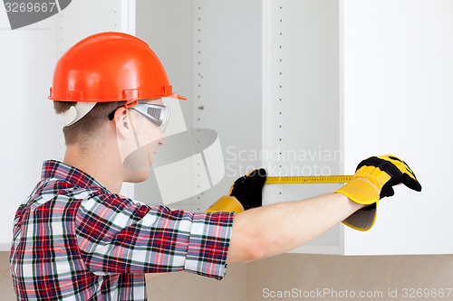 Image of builder measures the length