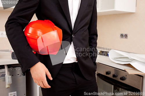 Image of engineer holding red helmet