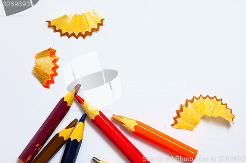 Image of several aged pencils and shavings on white background
