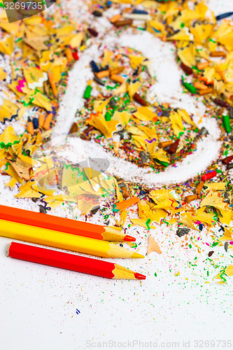Image of heart, three pencils and colored wooden shavings