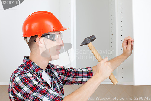 Image of repairman with hammer