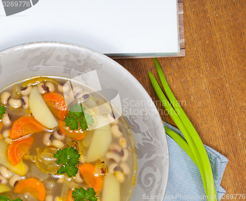 Image of bean soup with carrots, potatoes, parsley and onions