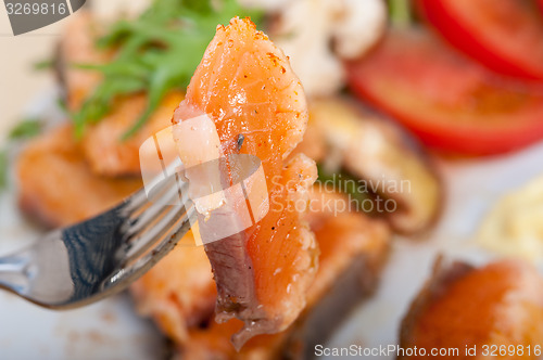 Image of grilled samon filet with vegetables salad