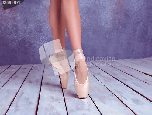 Image of The feet of a young ballerina in pointe shoes 
