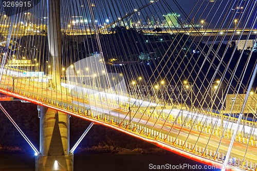 Image of highway bridge at night with traces of light traffic