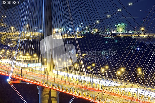 Image of highway bridge at night with traces of light traffic