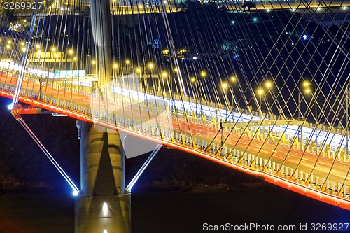 Image of highway bridge at night with traces of light traffic