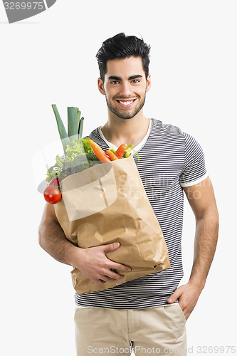 Image of Man carrying a bag full of vegetables