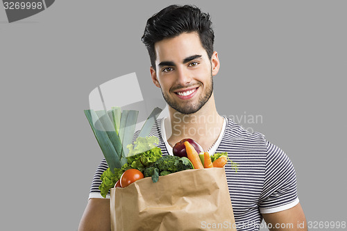 Image of Man carrying a bag full of vegetables