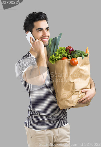 Image of Man carrying a bag full of vegetables