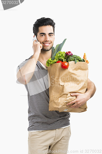 Image of Man carrying a bag full of vegetables