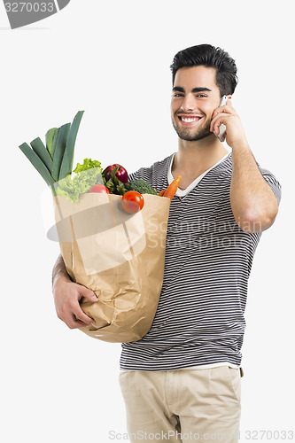 Image of Man carrying a bag full of vegetables