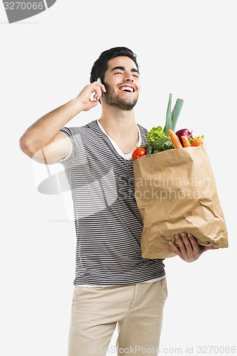Image of Man carrying a bag full of vegetables