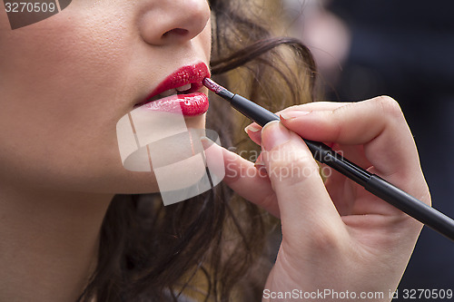 Image of Applies lipstick