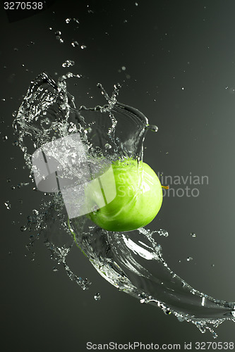 Image of Green apple with water splash, on black