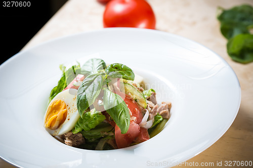 Image of plate of spring mix salad with strawberry, eggs and tuna