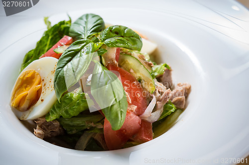 Image of plate of spring mix salad with strawberry, eggs and tuna