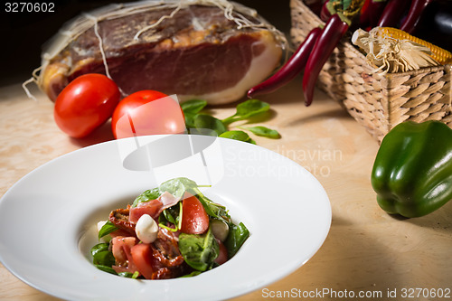 Image of Salad with strawberry, prosciutto, herbs, cottage cheese and blackberry balsamic vinegar.