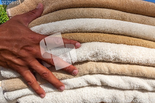 Image of Stack of white  and broun plush hotel towels 
