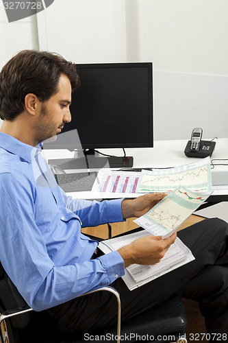 Image of Young man reading written agreements for work