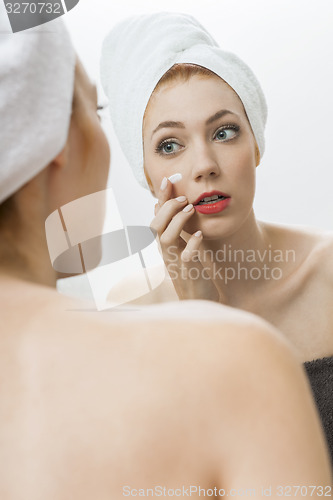 Image of Woman After Shower Applying Cream on her Face