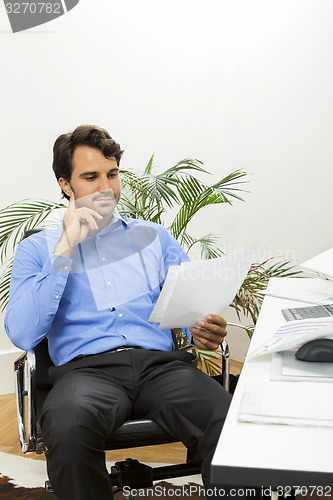 Image of Young man reading written agreements for work