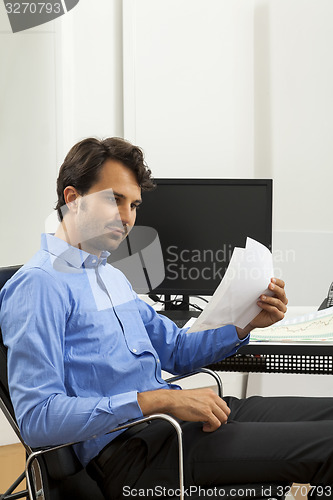 Image of Young man reading written agreements for work