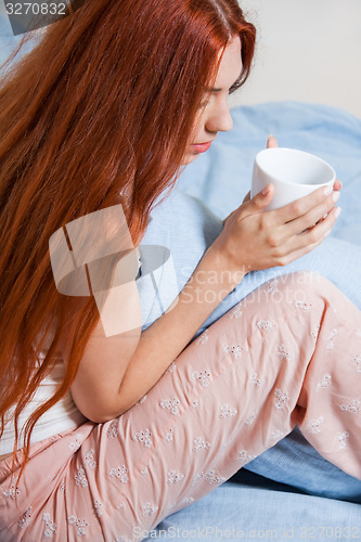 Image of Pensive Woman Having an Early Coffee at her Bed