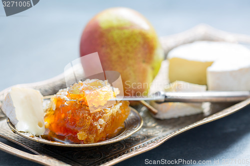 Image of Honey comb, ripe pear and brie.