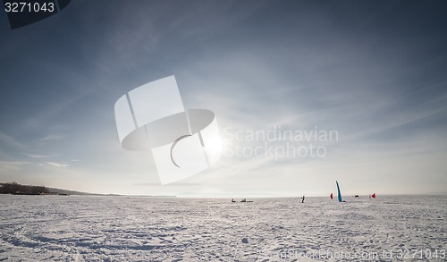 Image of Kiteboarder with blue kite on the snow