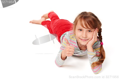 Image of Front view of smiling child girl lying on stomach