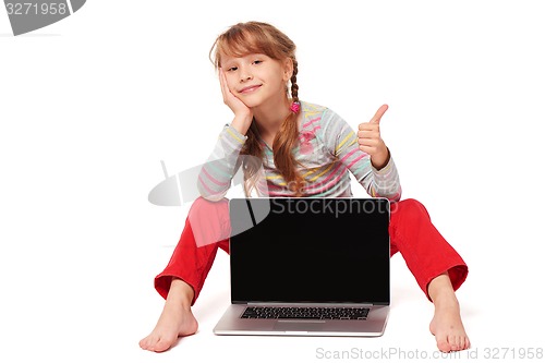 Image of Little girl sitting on floor showing laptop screen