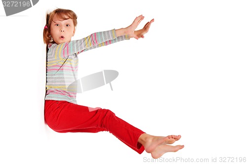 Image of Funny image of amazed girl sticked to white wall