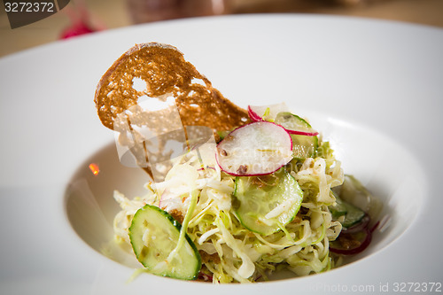 Image of Salad from cabbage, herbs, cucumber and radish in bowl.