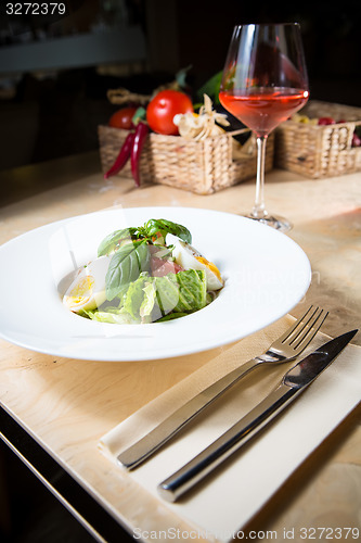 Image of plate of spring mix salad with strawberry, eggs and tuna