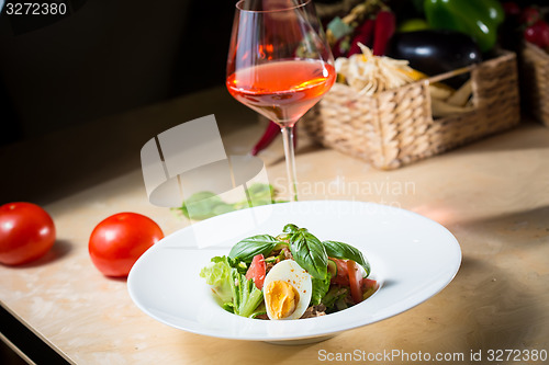 Image of plate of spring mix salad with strawberry, eggs and tuna